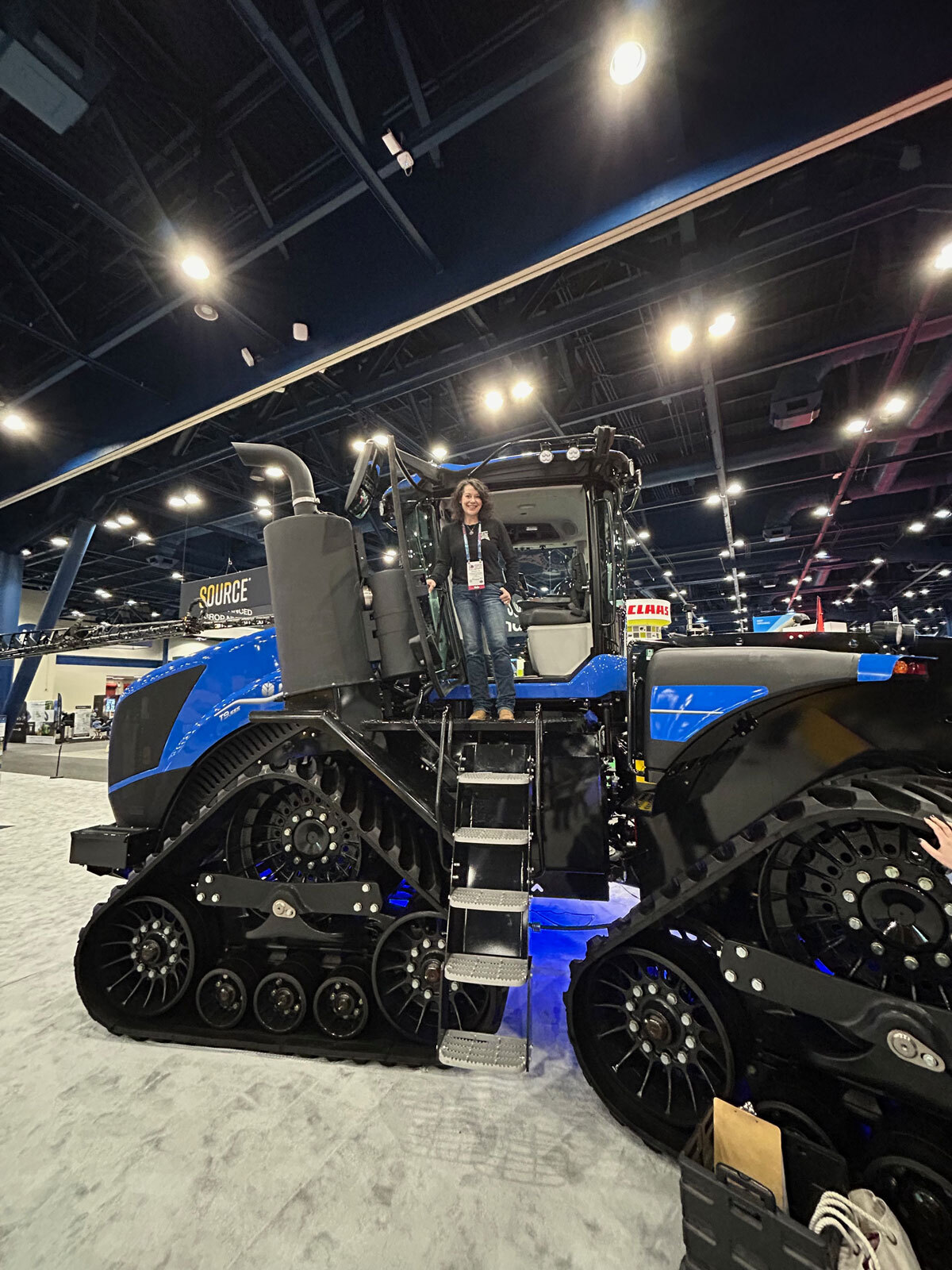 Woman standing in a New Holland tractor at Commodity Classic.