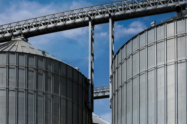 Two grain bins under a clear blue sky